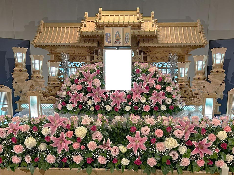 白木祭壇の周りには白やビンクを基調とした、たくさんの花が飾られています