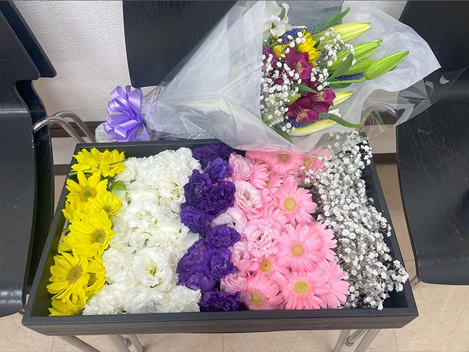 色とりどりの花がケースに入れられており、隣には百合などを使用した花束が置かれています